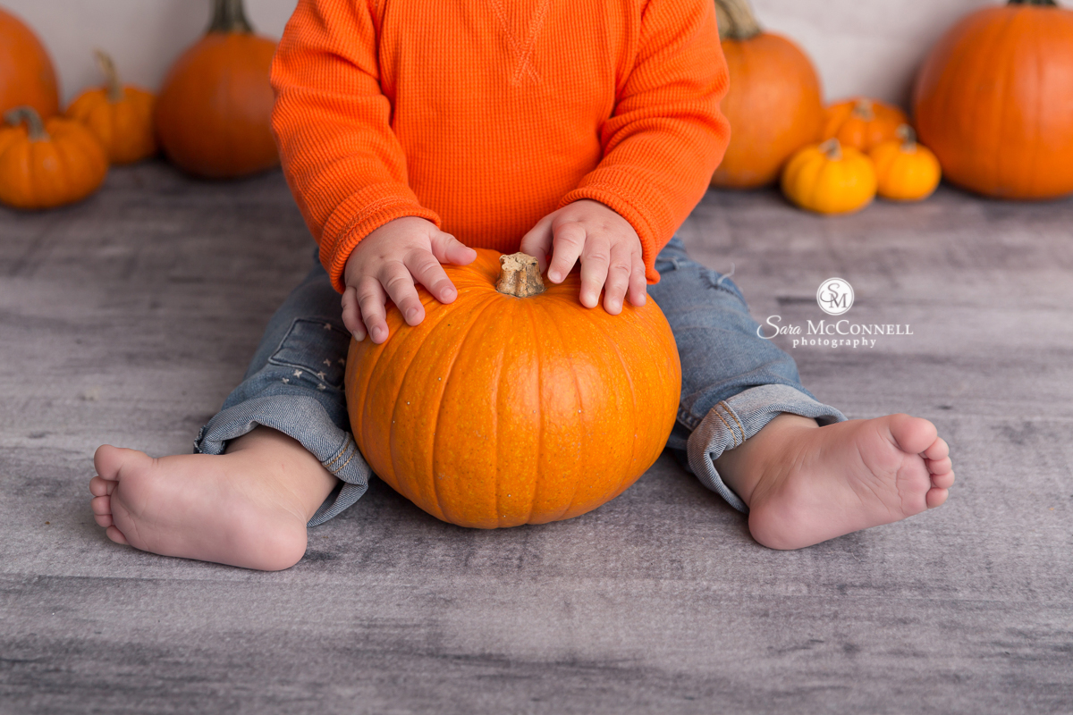 baby holding a pumpkin