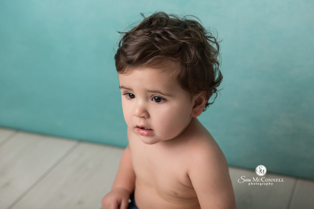 baby in front of turquoise backdrop