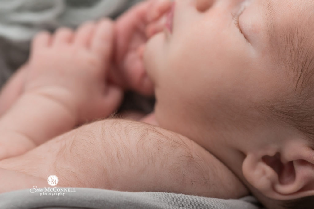 close up of newborn baby holding parent's hand