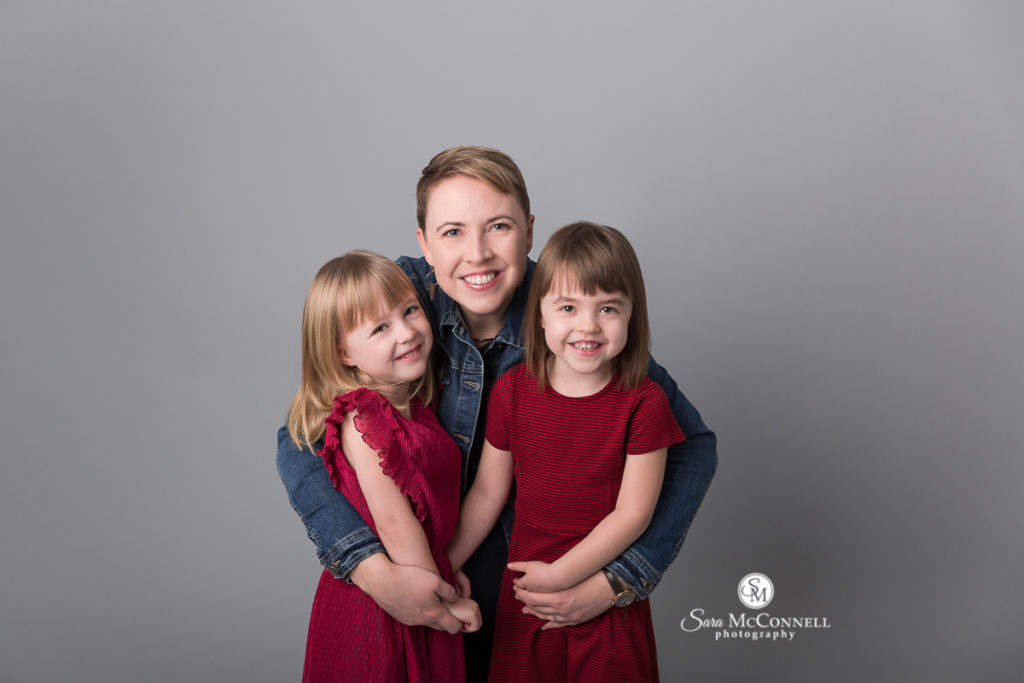 parents with two daughters smiling for family photos