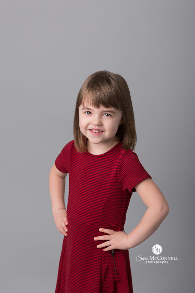 little girl in a red dress smiling
