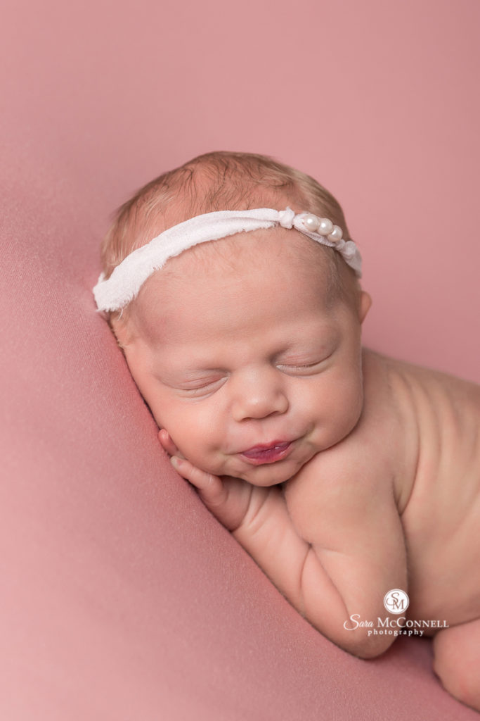 newborn baby sleeping on pink