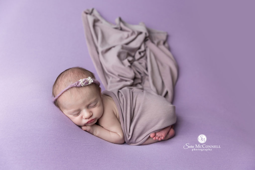 baby wrapped in purple on a purple blanket