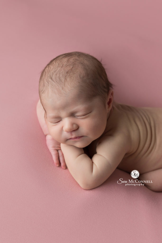newborn baby on pink backdrop