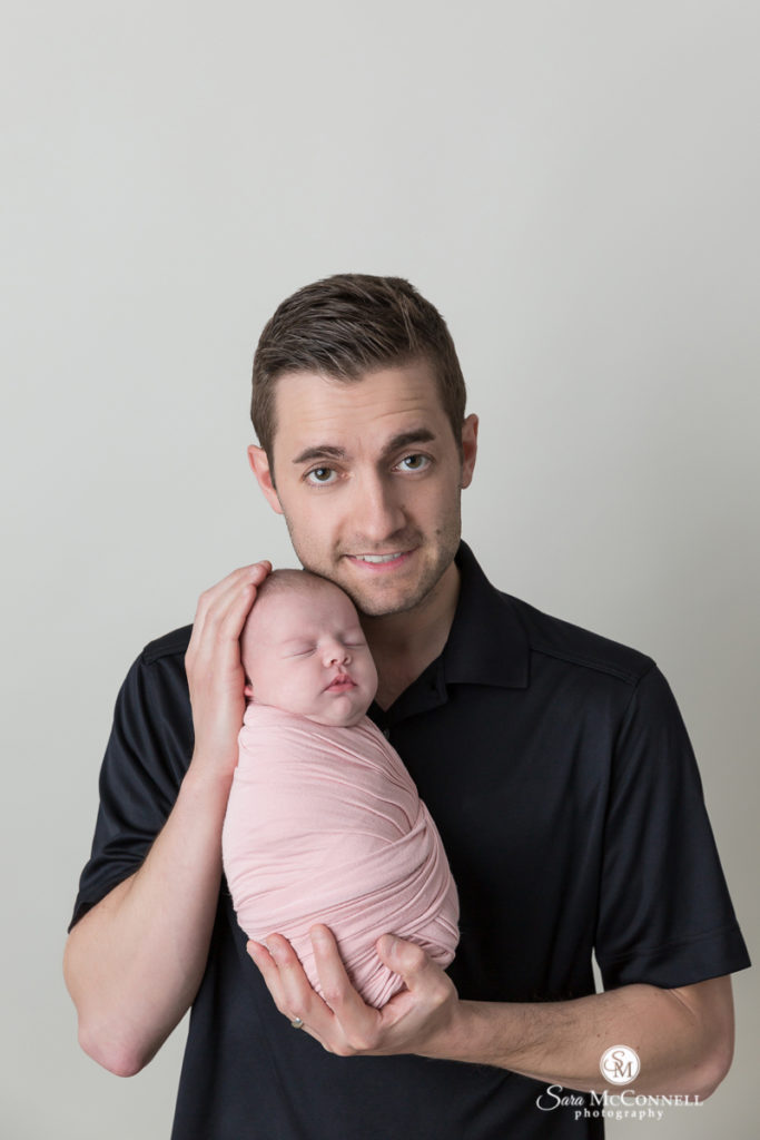father holding daughter wrapped in pink