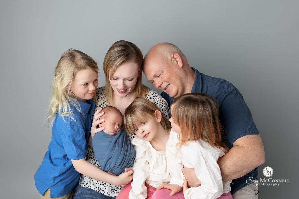 Photo of smiling family taken by Ottawa newborn photographer in a Digital Backdrops For Newborn Sessions blog post