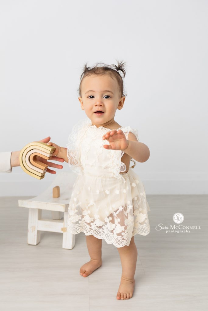 Photo of a one year girl standing in a blog post about displaying first birthday photos. Maternity photographers ottawa.