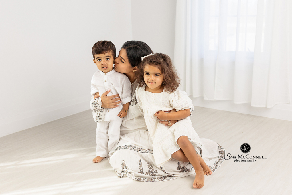 Photo of a mom cuddling her two children in a blog post called "What is a candid photo?". Ottawa portrait photographers.