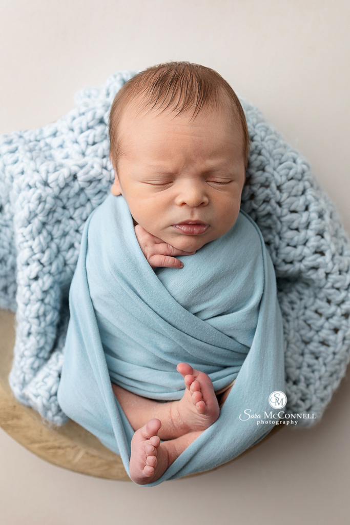 A photo of a sleeping newborn posed in a prop in a blog post about having just a few newborn photos. 